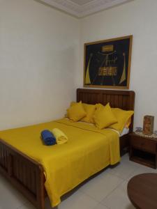 达喀尔Studio Confort Fann Hock的一间卧室配有一张带黄色床单的大床