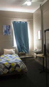 RedbankHotel Kerwick的一间卧室配有床和蓝色窗帘