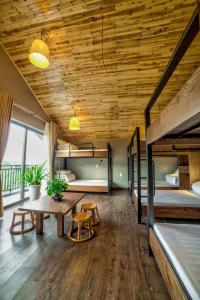 萨帕Lustig Hostel的客房设有两张双层床和木制天花板。