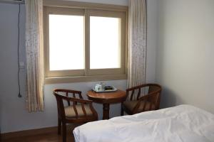 济州市奥拉星汽车旅馆的一间卧室配有桌子、两把椅子和窗户