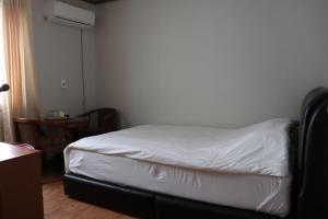 济州市奥拉星汽车旅馆的一间小卧室,配有白色床单