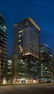 首尔L7 Gangnam的一座高大的建筑,晚上在城市里亮着灯