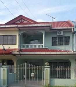 山打根GuestHouse Taman Megah, Lot 19的一座带红色屋顶的绿色房子