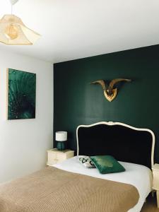 里夫杜海滩Appartement vue sur mer île de ré的一间卧室配有一张带绿色墙壁的床