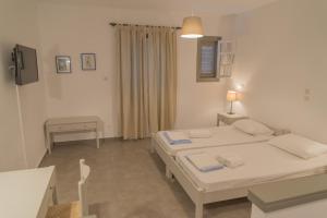 加夫里翁奥斯特里亚公寓酒店的客房设有两张床、一张桌子和一张书桌。