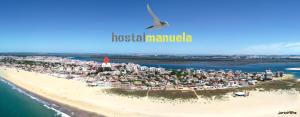 蓬塔翁布里亚曼努埃拉旅馆的鸟飞过海滩与城市