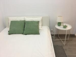 里斯本New Luxury Apartment - Lisbon Center的一张带绿色枕头和边桌的白色床