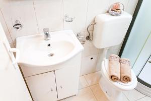 尼亚卢卡Guest House Mara的白色的浴室设有卫生间和水槽。