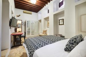 迪拜XVA艺术酒店的卧室配有白色的床和书桌