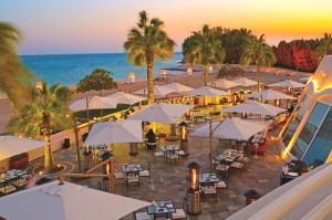 阿可贺巴Sunset Beach Resort Marina & Spa的海滩上方的桌子和遮阳伞