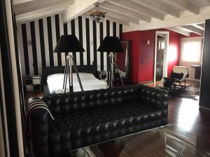 梅利德Le Suites al Lago的客厅配有真皮沙发和床。