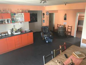 特罗吉尔特罗吉尔马里纳旅舍的厨房配有橙色橱柜和桌椅