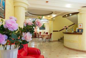 阿德勒沙姆沙伊赫酒店的大堂设有桌椅和粉红色的鲜花