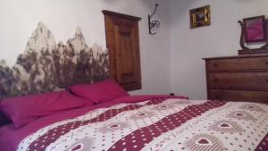 巴切诺Tana del Paradiso的一间卧室配有一张带紫色床单的床和梳妆台