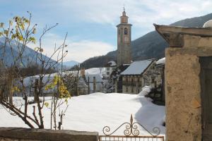 巴切诺Tana del Paradiso的雪中带钟楼的小城镇