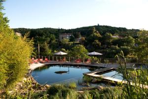 贝莱斯塔Domaine Riberach - Restaurant étoilé - Spa - Piscine naturelle - Vignoble bio的一个带椅子和遮阳伞的大型游泳池