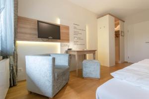 巴特拉斯费艾母奥尔巴赫特尔酒店的一间卧室配有一张床、一张书桌和一台电视。