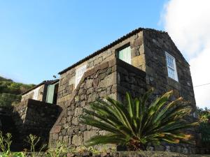 Terra AltaCasa Adega Alto do Passinho的一座石头建筑,前面有植物