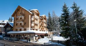 拉克吕萨阿尔卑酒店的地面上积雪的大公寓楼