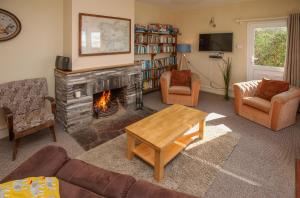 伦维尔Cottage 202 - Renvyle的客厅设有壁炉、沙发和椅子
