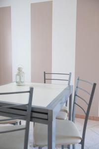 卡萨莱蒙费拉托Appartamento Il Castello的餐桌、椅子和白色桌子