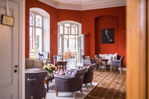 维斯马斯古罗斯盖梅尔酒店的客厅设有红色的墙壁和椅子