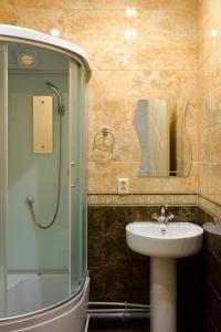 巴尔瑙尔Guest House on Partizanskaya的浴室配有盥洗盆和带镜子的淋浴