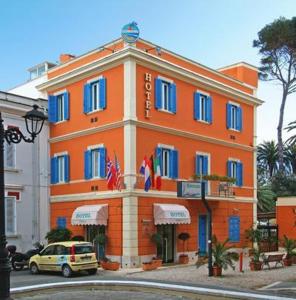 圣塔马利奈拉伊索拉酒店的一座橙色的建筑,街道上设有蓝色的窗户