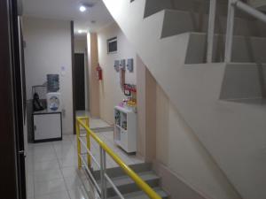 雅加达Kantos Guest House的走廊上有一个黄色栏杆的楼梯