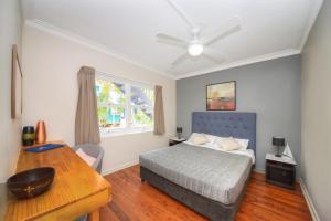 黄金海岸Backpackers In Paradise 18-35 Hostel的一间卧室配有一张床、一张书桌和一个窗户。