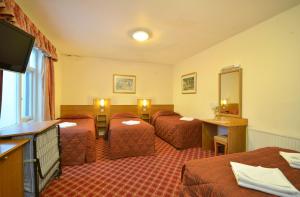 伦敦西摩尔酒店的酒店客房设有三张床和电视。