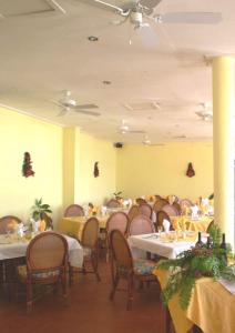 圣乔治卡里纳格海滩度假酒店的用餐室配有桌椅和黄色的墙壁