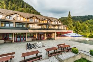 格吕瑙JUFA Hotel Grünau im Almtal的一座带长椅和遮阳伞的大型建筑