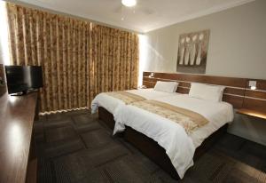 东伦敦奥斯纳酒店的一间卧室配有一张大床和一台平面电视