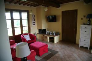 渥尔特拉La Fonte al Prete的客厅配有红色椅子、桌子和电视
