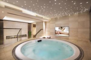 深圳深圳盛捷君临天下服务公寓的带电视的浴室设有大浴缸