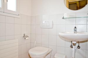 格林德尔瓦尔德Apartment Kiwi rechts - GRIWA RENT AG的白色的浴室设有卫生间和水槽。