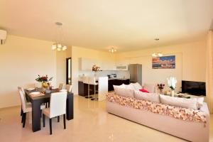 斯泰洛米诺斯Luxury Suites in Stavromenos的带沙发的客厅和用餐室