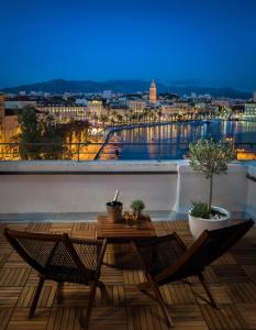 斯普利特Belvedere Luxury Rooms - Breathtaking View的设有一个配有桌椅并享有美景的阳台。