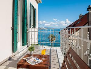 斯普利特Belvedere Luxury Rooms - Breathtaking View的阳台配有桌子,享有海景。