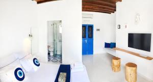 金尼昂Loukia Studios & Suites的一间白色的房间,设有蓝色的门和电视