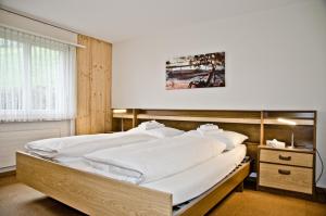 格林德尔瓦尔德Apartment Schönegg - GRIWA RENT AG的一间卧室配有一张带白色床单的大床