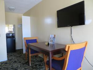 长滩水上冒险乐园旅馆的一间设有桌椅的房间,墙上配有电视