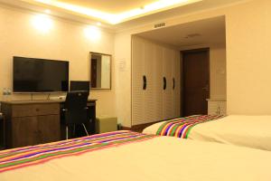 延吉韩世宾馆的酒店客房设有两张床和一张书桌及电视