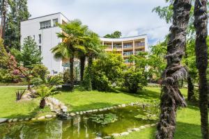 洛迦诺Tertianum Residenza Hotel & Ristorante Al Parco的一座建筑前有池塘的酒店
