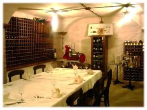 帕杜拉Hotel Certosa的用餐室配有白色桌椅和葡萄酒瓶