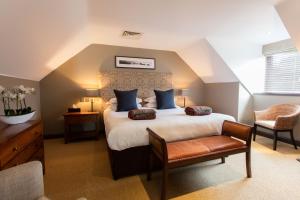 诺里奇巴尔汉姆布鲁姆酒店、高尔夫&SPA的一间卧室配有一张大床和一把椅子