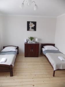 扎托尔Noclegi Zator的一间卧室设有两张床,铺有木地板