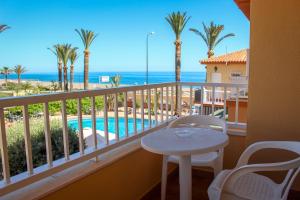 贝纳哈拉菲埃斯佩兰萨旅馆的阳台配有桌子,享有海景。