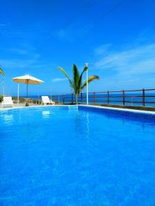 卡诺阿斯德蓬萨尔Bella Vista condominio的毗邻大海的大型蓝色游泳池
